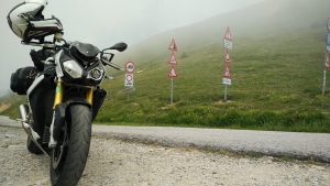 Motorrad vor Verkehrsschildern am Solle die Sampeyre