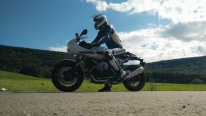 BMW R nineT Racer in weiß-blau-rot und Biker in Lederkombi blau-weiß