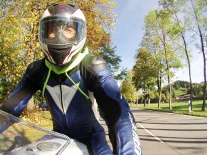 Motorradfahrer auf Allee in herbstlichen Farben.