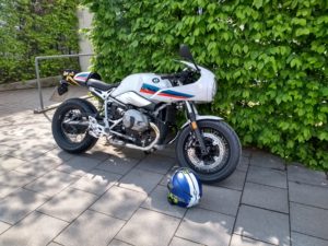 BMW R NineT Racer vor grüner Hecke