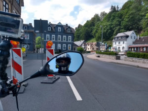 Motorradfahrer im Rückspiegel dahinter Baustelle